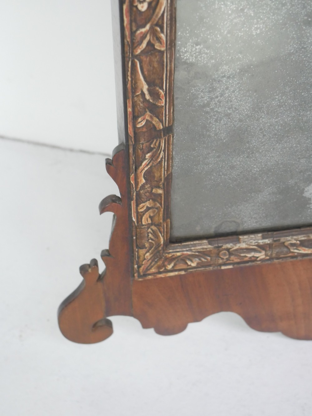 A Georgian mahogany wall mirror featuring a scroll-carved fretwork frame with an inner gilded slip border. View VII
