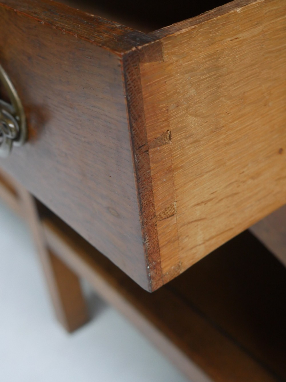 An Arts and Crafts solid oak dresser featuring an upper section with a central mirror flanked by two small cupboards, set above a lower sideboard base with drawers and side doors. View VI