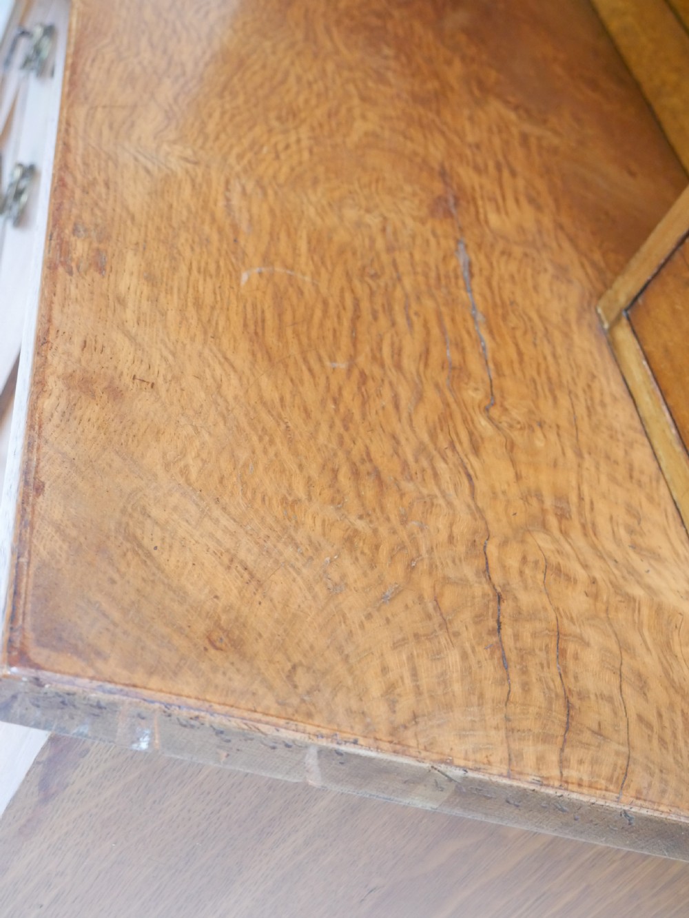 An Arts and Crafts solid oak dresser featuring an upper section with a central mirror flanked by two small cupboards, set above a lower sideboard base with drawers and side doors. View XIV