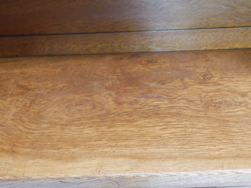 An Arts and Crafts solid oak dresser featuring an upper section with a central mirror flanked by two small cupboards, set above a lower sideboard base with drawers and side doors. View XVII