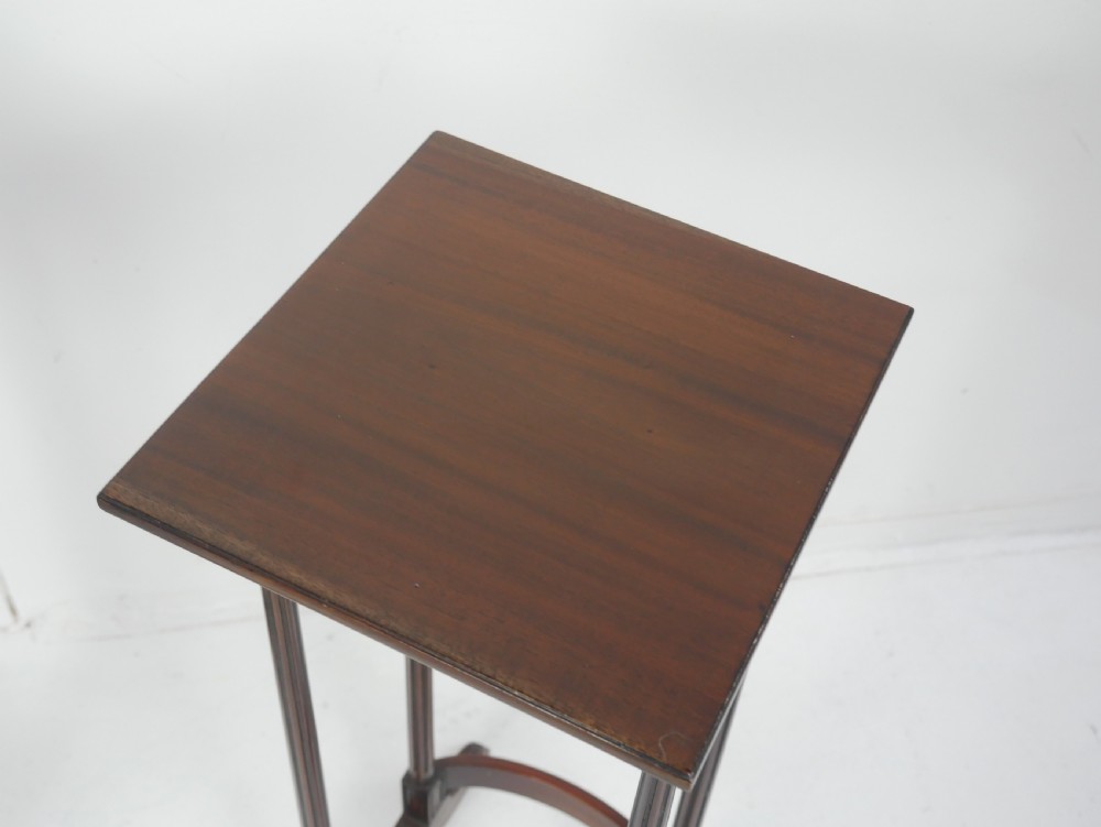 A set of four dark mahogany rectangular nesting tables with slender reeded legs and curved stretchers stacked together. View III