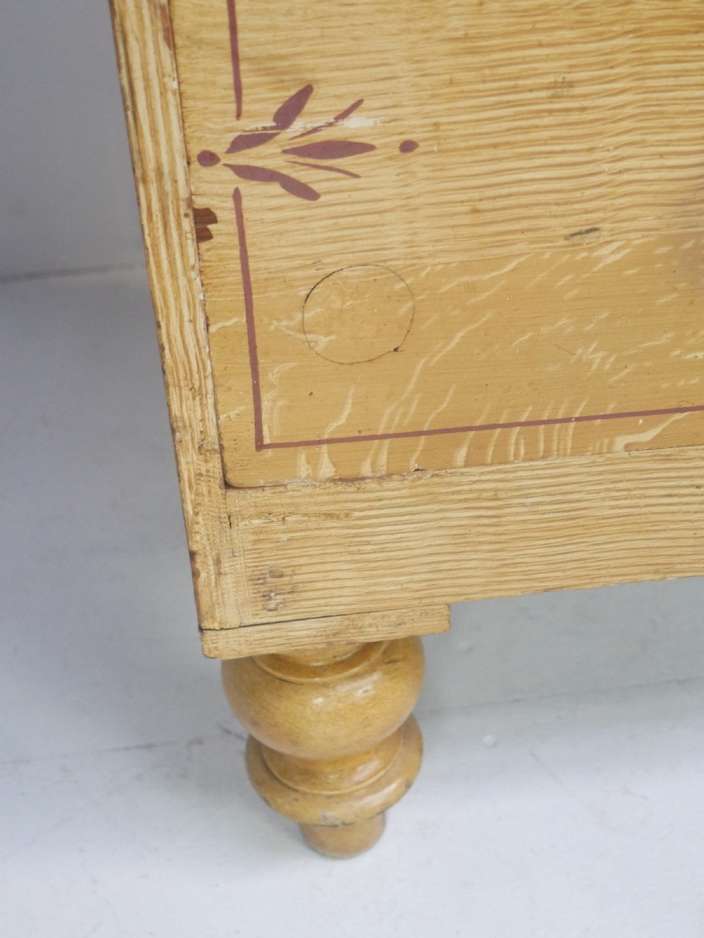 An antique Victorian painted pine chest featuring two short over two long drawers with faux graining, red line borders, wooden knobs, and turned feet. View VIII
