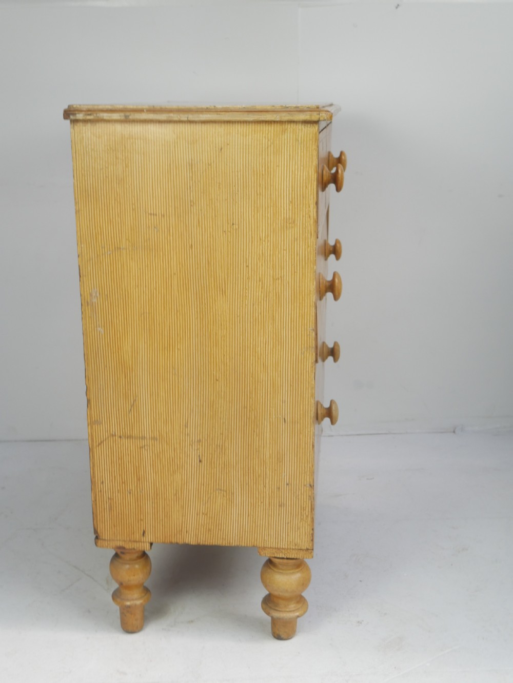 An antique Victorian painted pine chest featuring two short over two long drawers with faux graining, red line borders, wooden knobs, and turned feet. View XIII