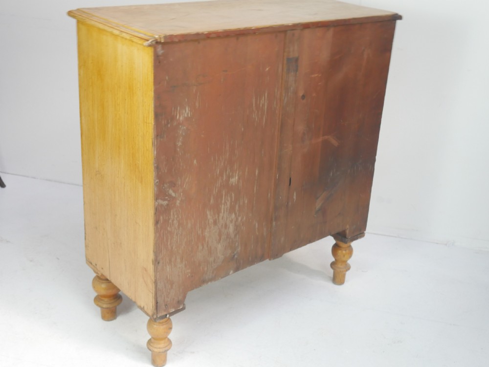 An antique Victorian painted pine chest featuring two short over two long drawers with faux graining, red line borders, wooden knobs, and turned feet. View XVI