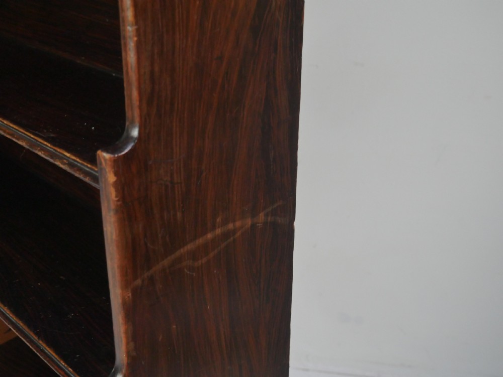 A dark brown 19th-century waterfall bookcase featuring four open stepped shelves, side profile cutouts, and turned legs. View III