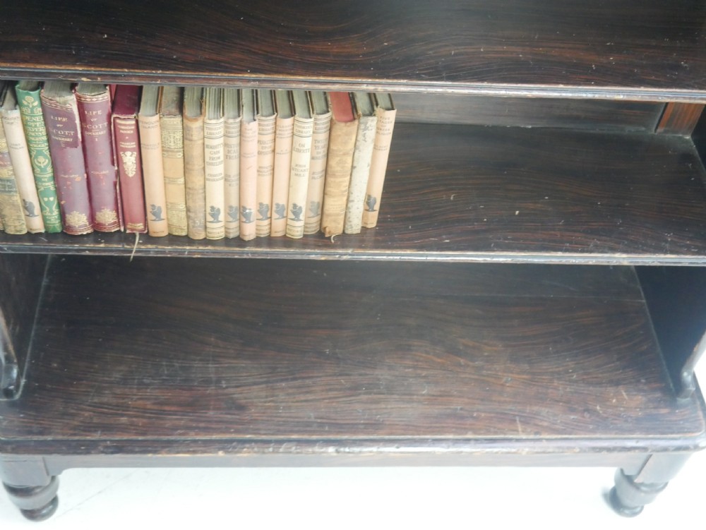 A dark brown 19th-century waterfall bookcase featuring four open stepped shelves, side profile cutouts, and turned legs. View VII