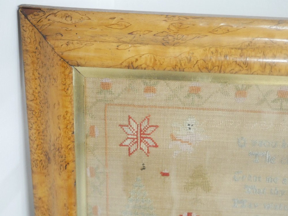 An 1822 hand-embroidered needlework sampler containing verse and decorative motifs, presented inside a glazed birdseye maple frame. View V
