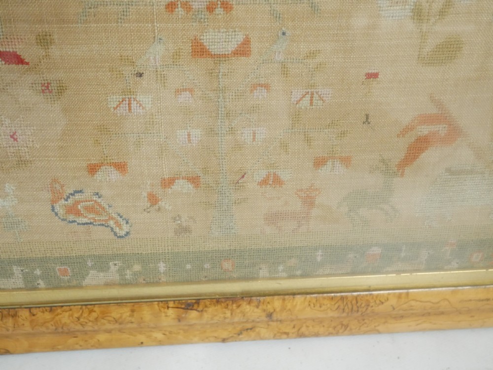 An 1822 hand-embroidered needlework sampler containing verse and decorative motifs, presented inside a glazed birdseye maple frame. View VIII