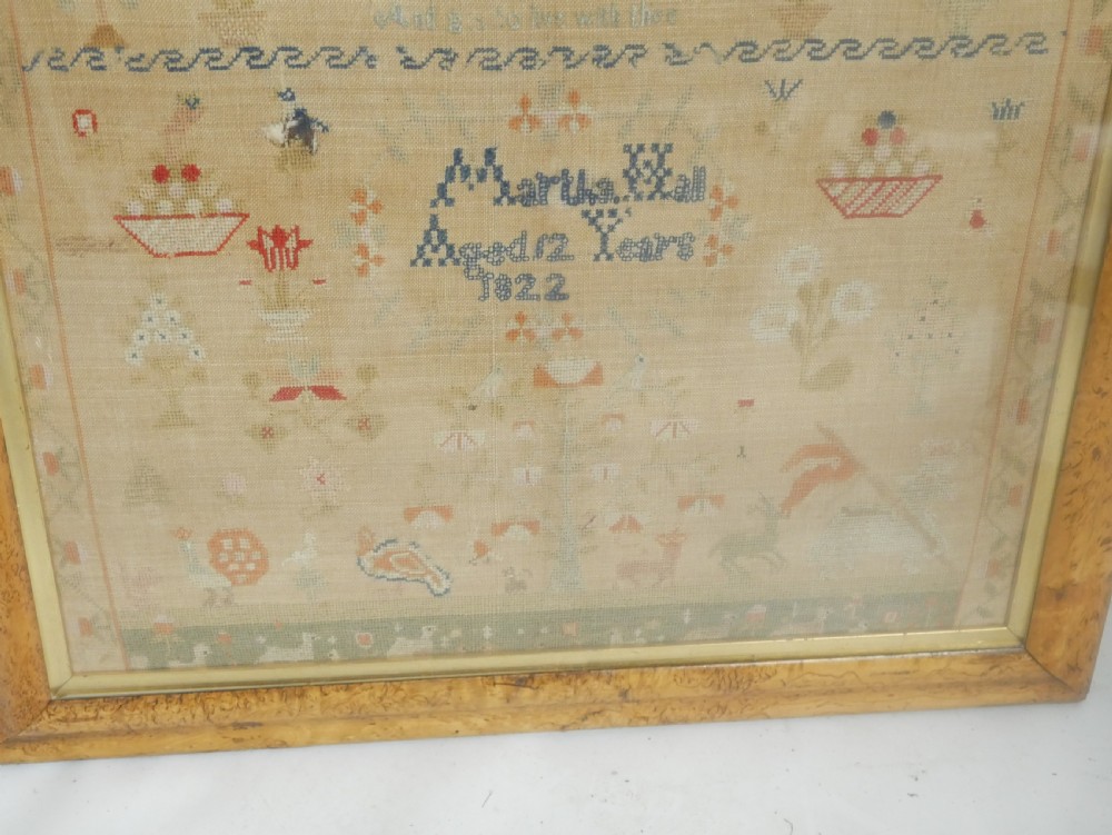 An 1822 hand-embroidered needlework sampler containing verse and decorative motifs, presented inside a glazed birdseye maple frame. View XIII