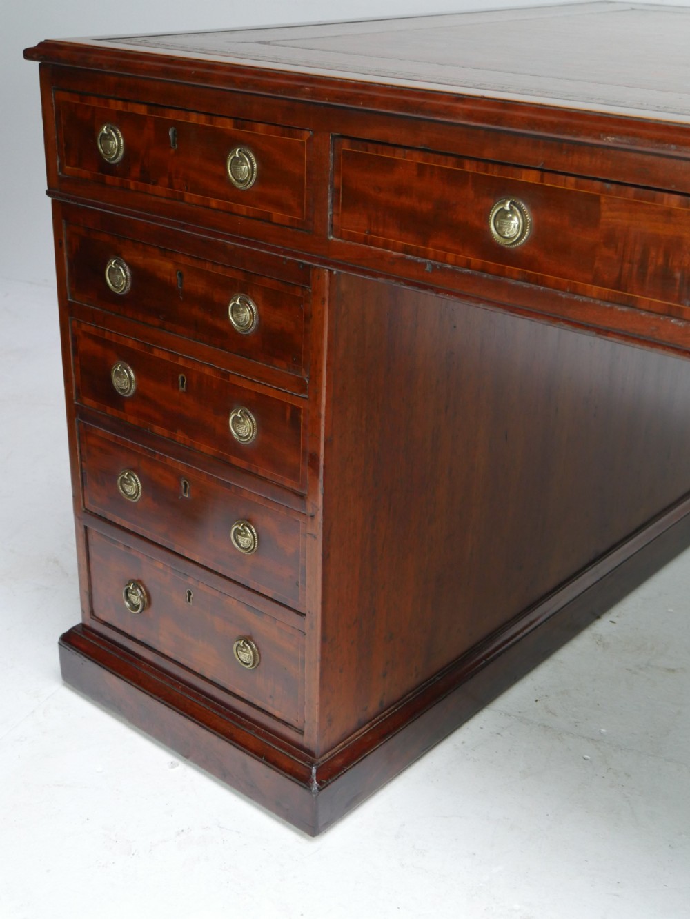 A 19th-century mahogany kneehole partners desk featuring twin pedestals, multiple drawers with brass drop handles, and a flat rectangular writing top. View IX