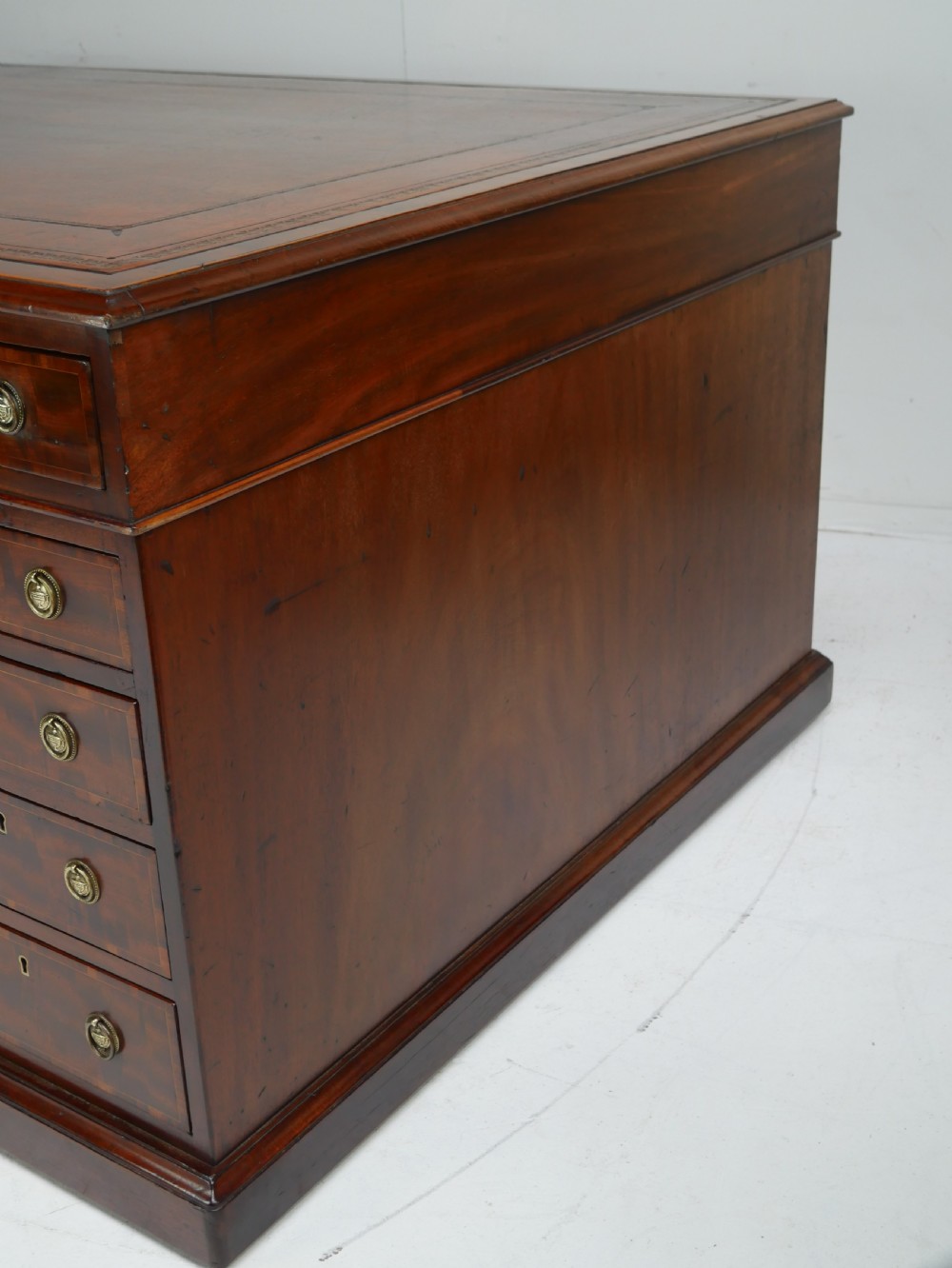 A 19th-century mahogany kneehole partners desk featuring twin pedestals, multiple drawers with brass drop handles, and a flat rectangular writing top. View XI