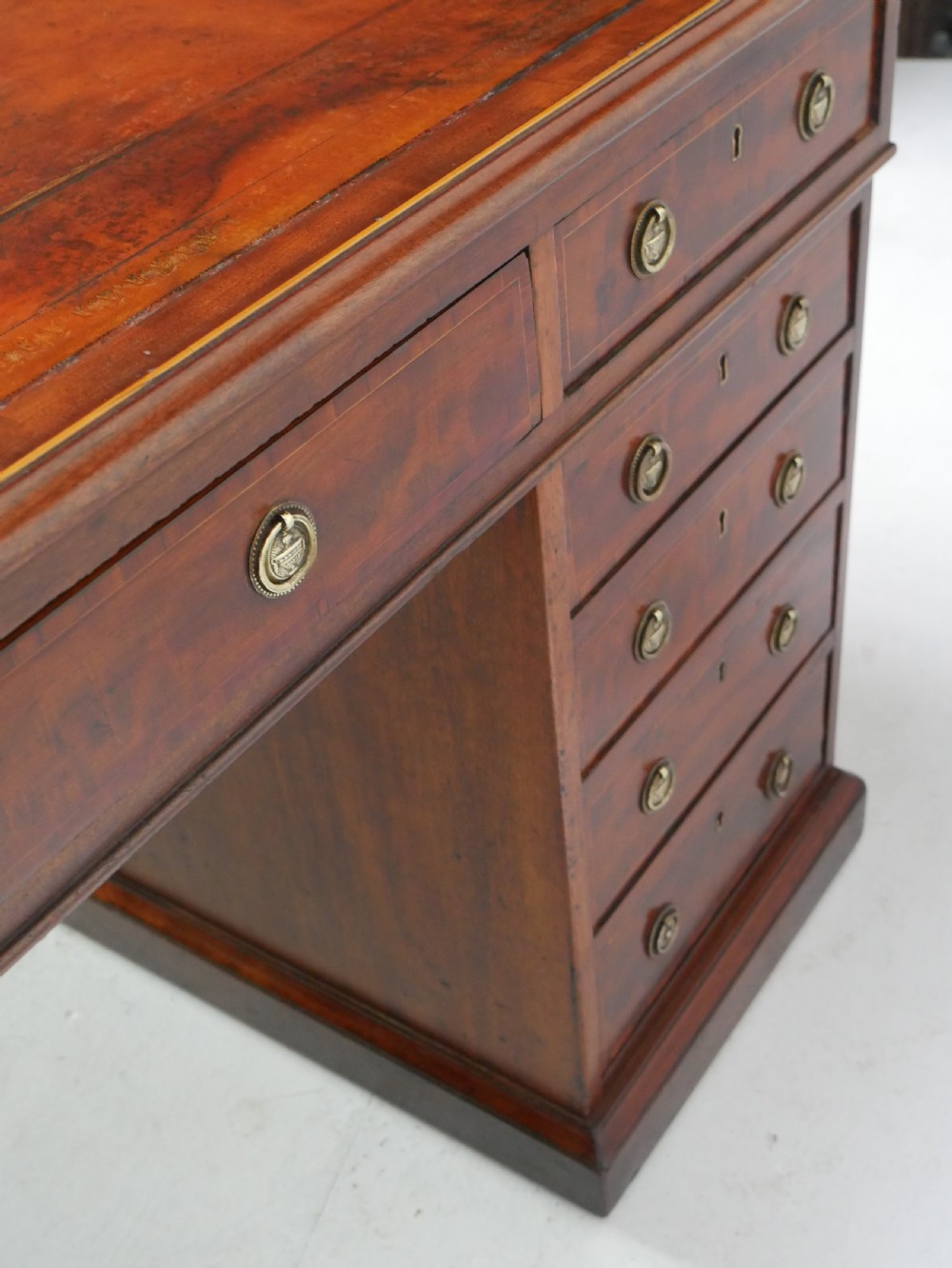 A 19th-century mahogany kneehole partners desk featuring twin pedestals, multiple drawers with brass drop handles, and a flat rectangular writing top. View XII