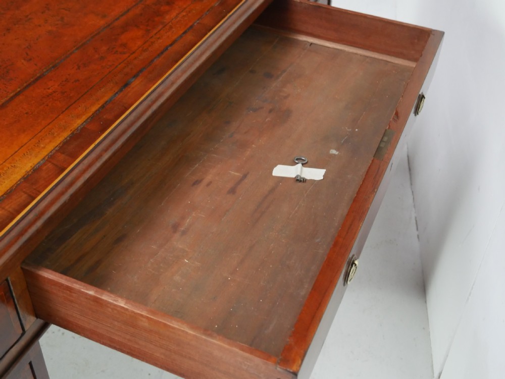 A 19th-century mahogany kneehole partners desk featuring twin pedestals, multiple drawers with brass drop handles, and a flat rectangular writing top. View XIII