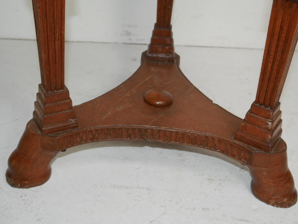A circular Anglo-Indian carved hardwood plant stand supported by three fluted legs topped with carved elephant heads. View VI