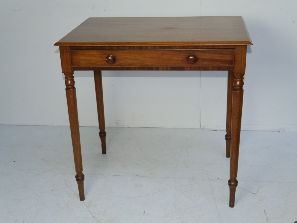 A Regency mahogany writing table featuring a single drawer with two turned wooden knobs, supported by four slim turned tapered legs.