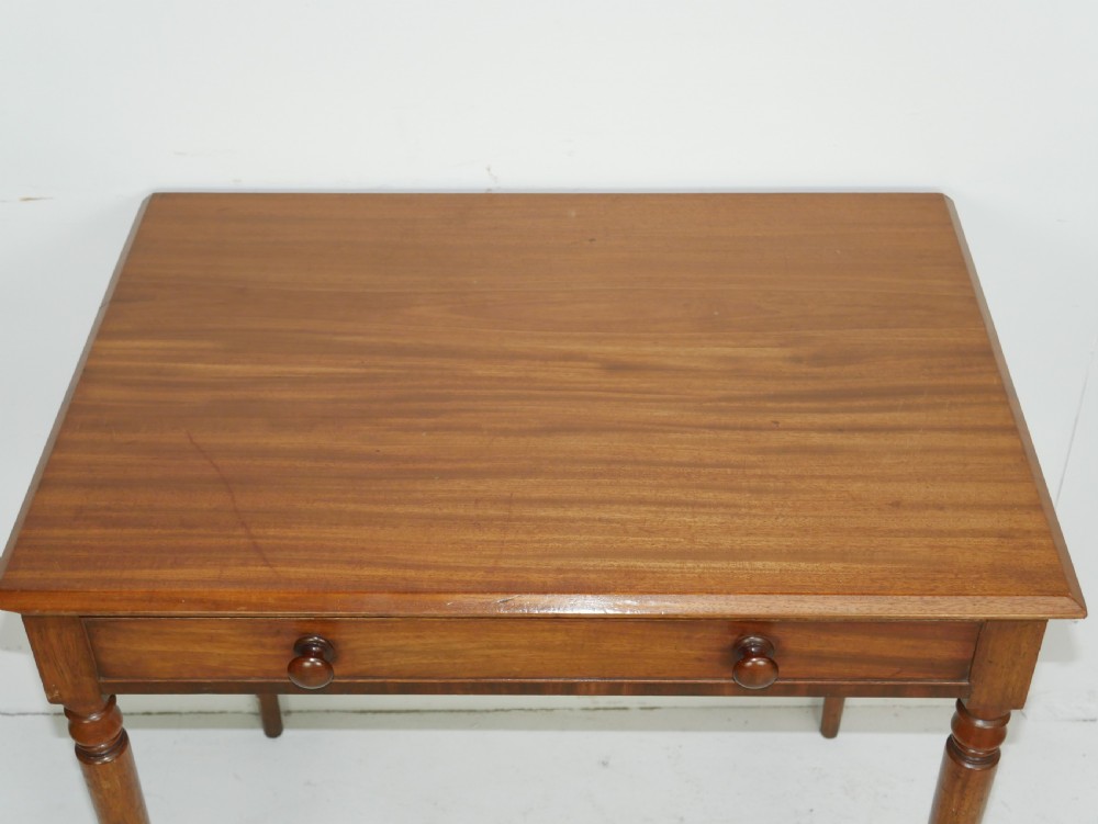 A Regency mahogany writing table featuring a single drawer with two turned wooden knobs, supported by four slim turned tapered legs. View II