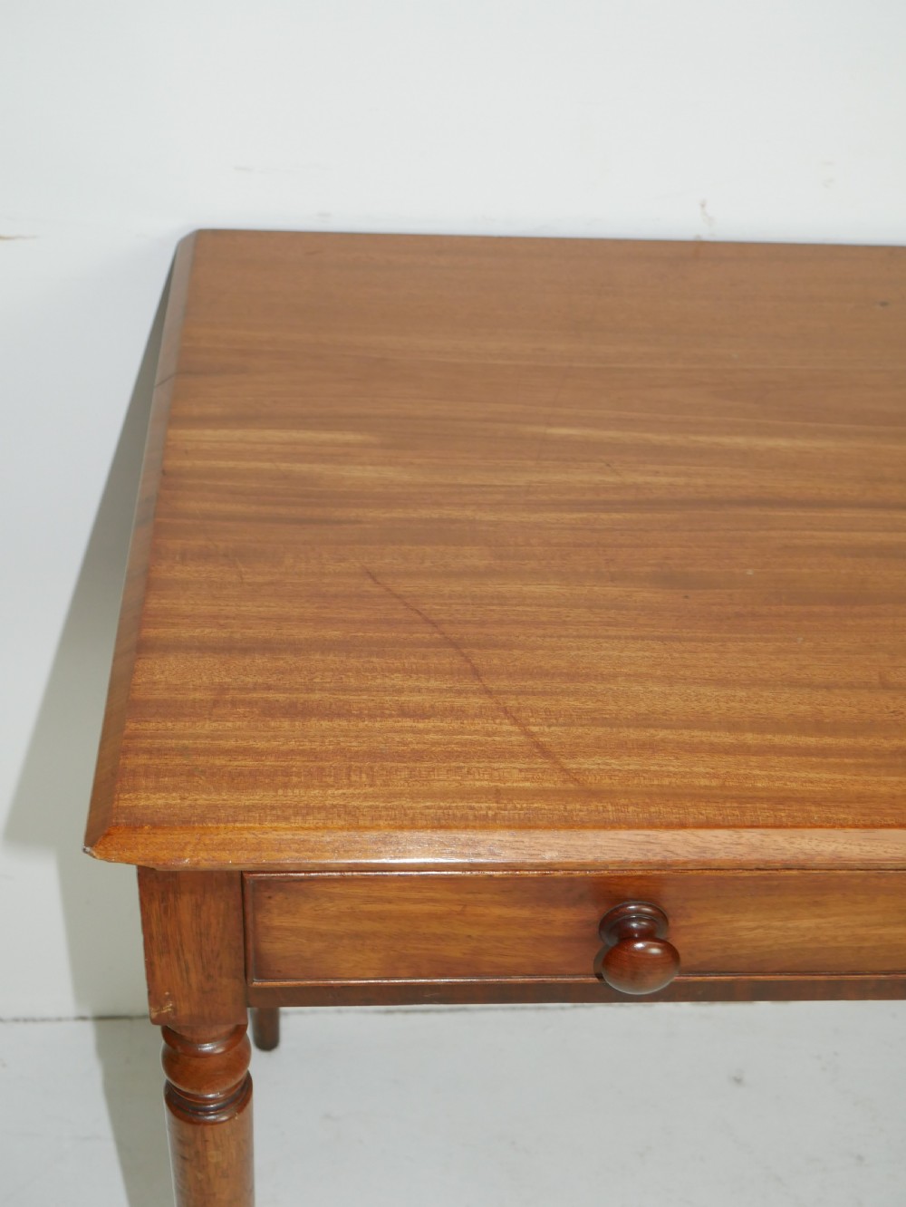 A Regency mahogany writing table featuring a single drawer with two turned wooden knobs, supported by four slim turned tapered legs. View III