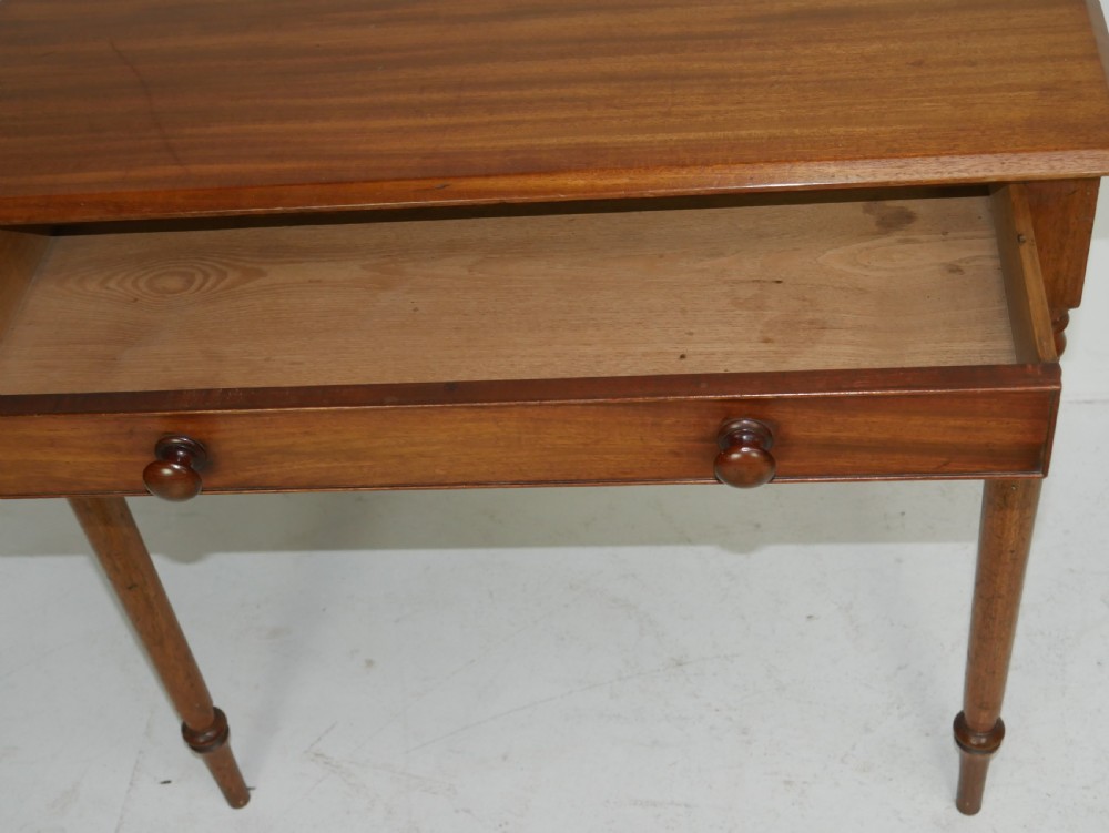 A Regency mahogany writing table featuring a single drawer with two turned wooden knobs, supported by four slim turned tapered legs. View VI