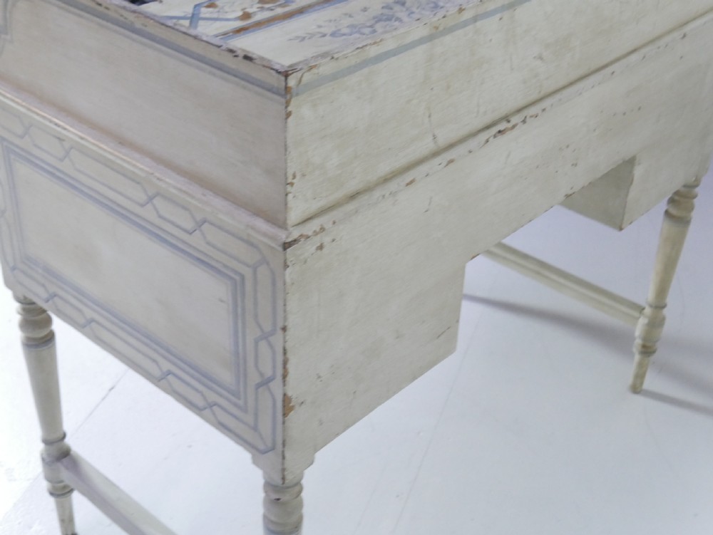 A 19th-century cream-painted wooden writing desk featuring five drawers, turned legs with stretchers, and a low gallery back decorated with light blue geometric painted borders. View IX