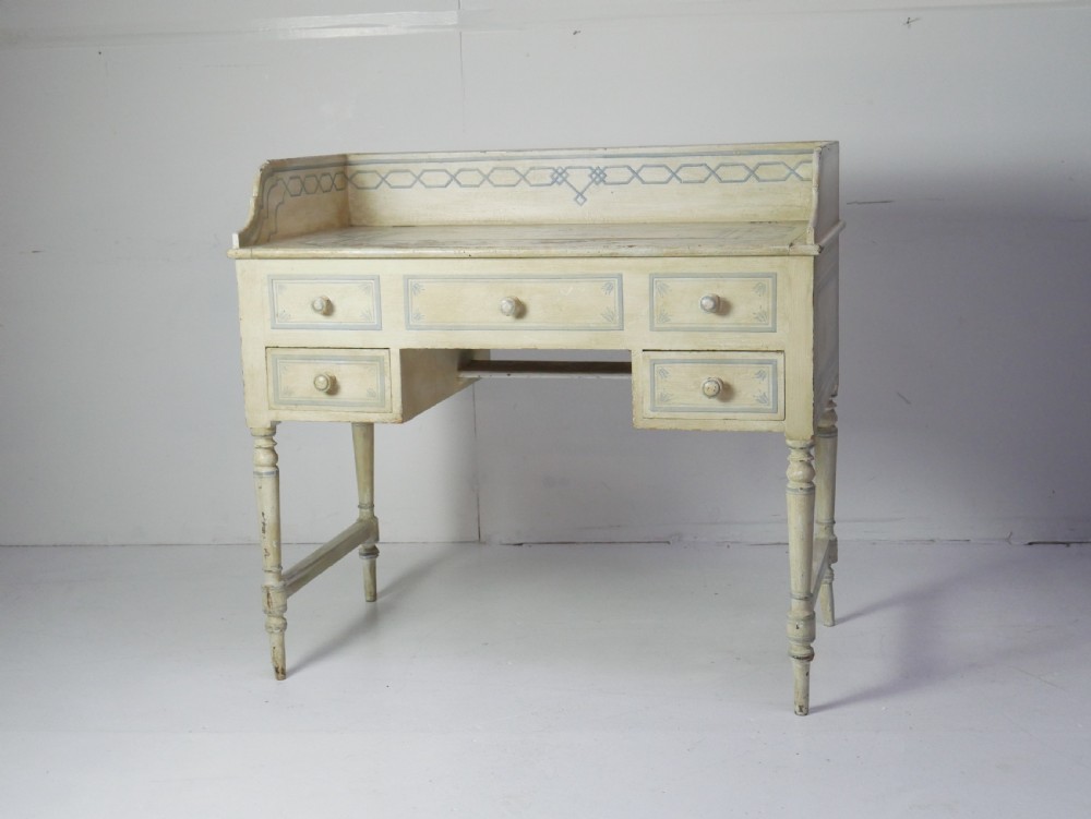 A 19th-century cream-painted wooden writing desk featuring five drawers, turned legs with stretchers, and a low gallery back decorated with light blue geometric painted borders. View XIII