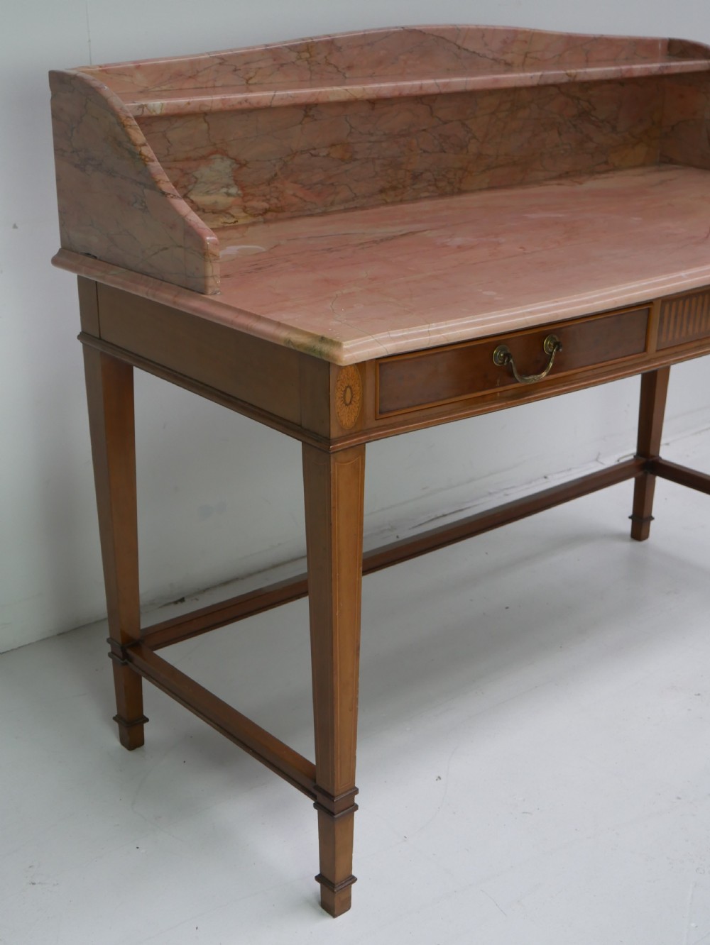 A mahogany writing table featuring two inlaid drawers, square tapered legs, and a pink marble top with a raised gallery back. View III