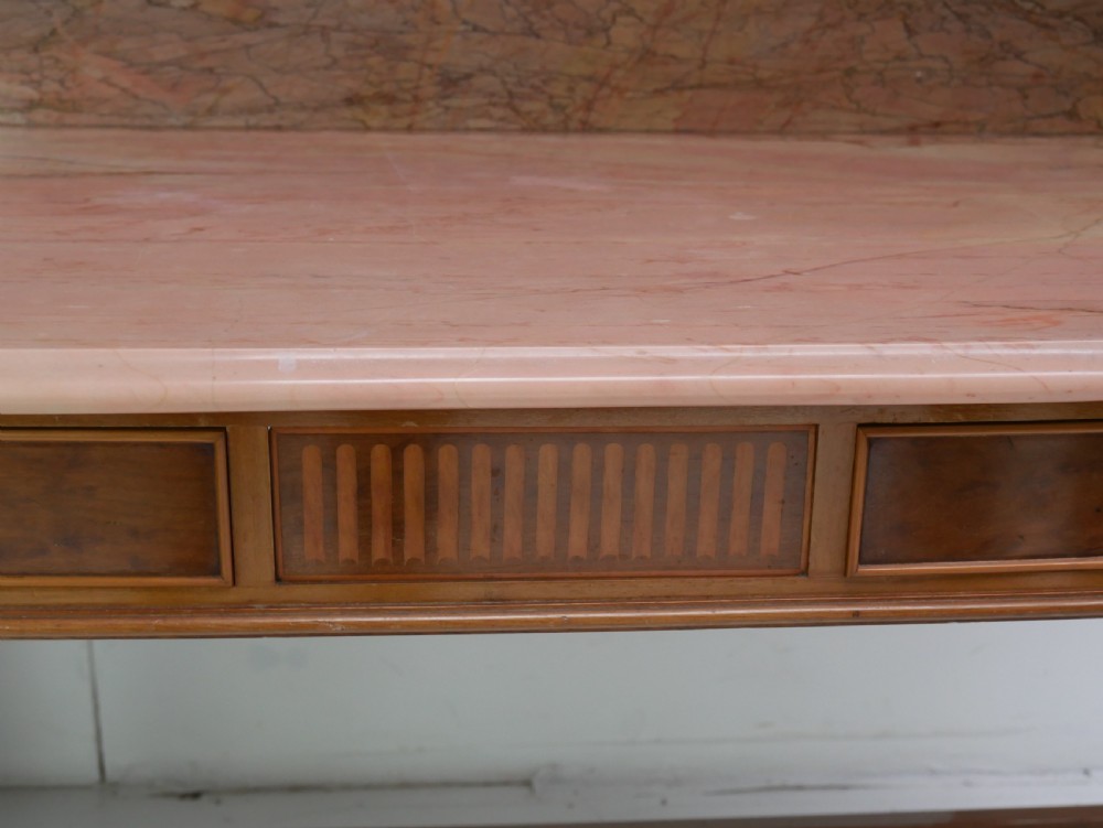 A mahogany writing table featuring two inlaid drawers, square tapered legs, and a pink marble top with a raised gallery back. View X