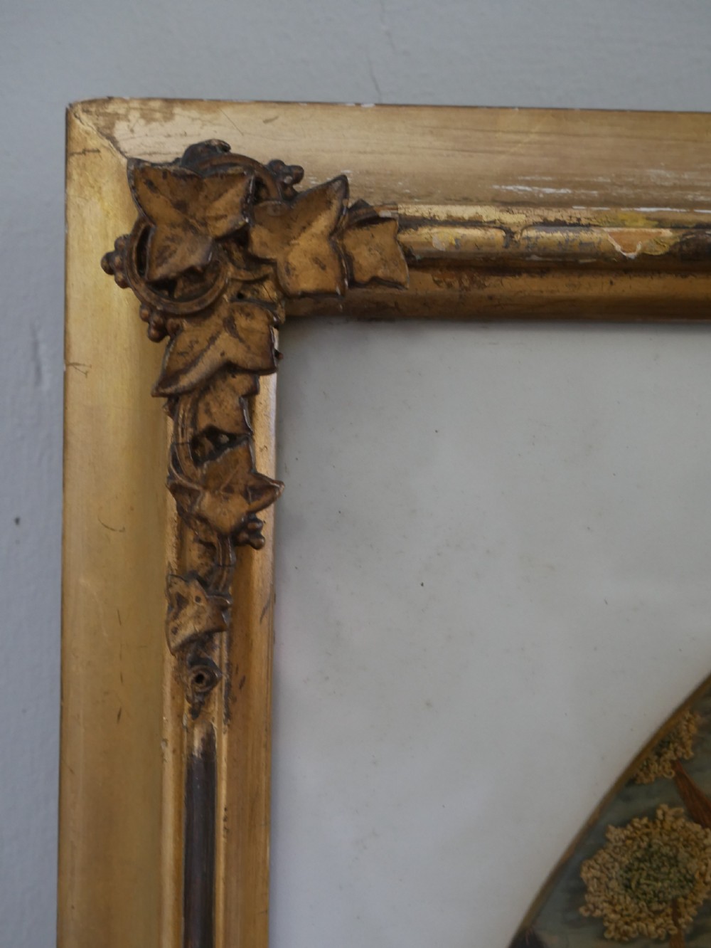 An early nineteenth-century oval crewel work embroidery depicting a shepherdess under a tree with sheep, set in a carved giltwood frame. View VI