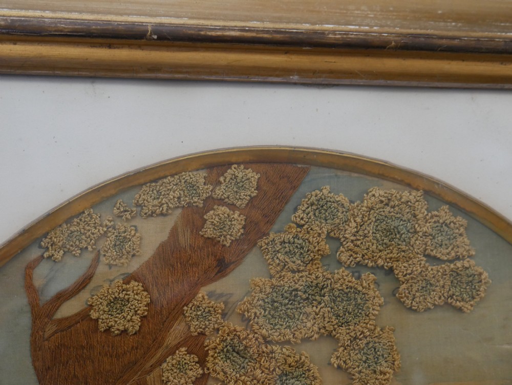 An early nineteenth-century oval crewel work embroidery depicting a shepherdess under a tree with sheep, set in a carved giltwood frame. View XIII