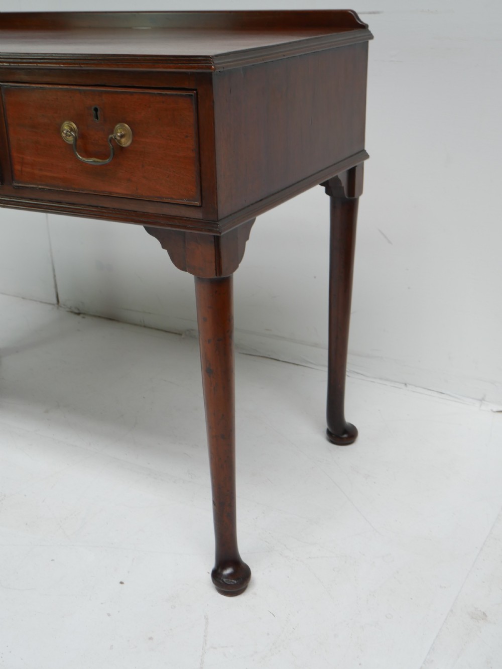 A 19th-century mahogany console table featuring three drawers with brass swan-neck handles and slender cabriole legs ending in pad feet. View II