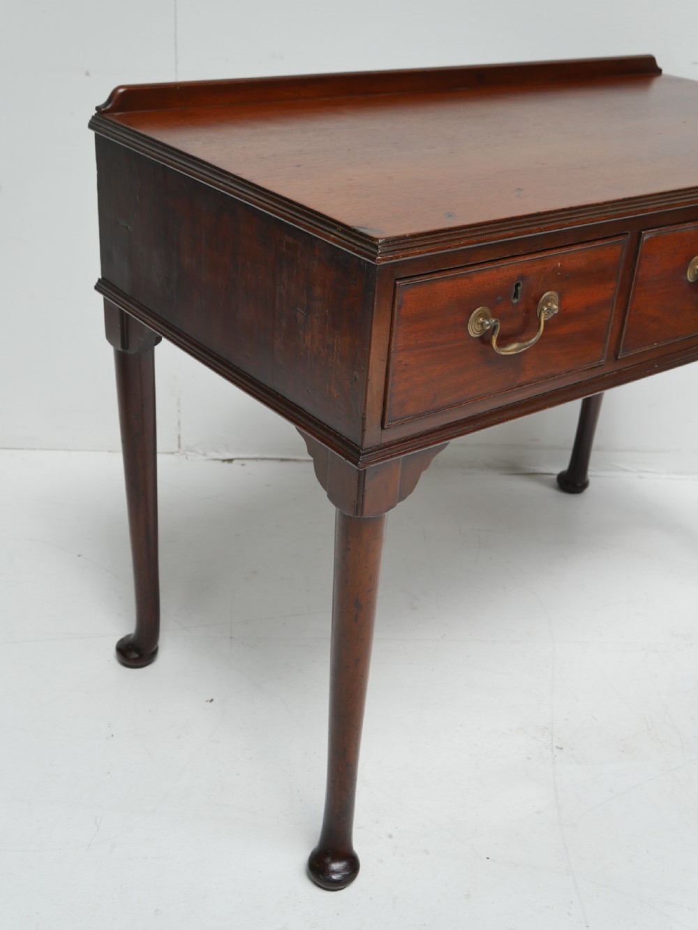 A 19th-century mahogany console table featuring three drawers with brass swan-neck handles and slender cabriole legs ending in pad feet. View V