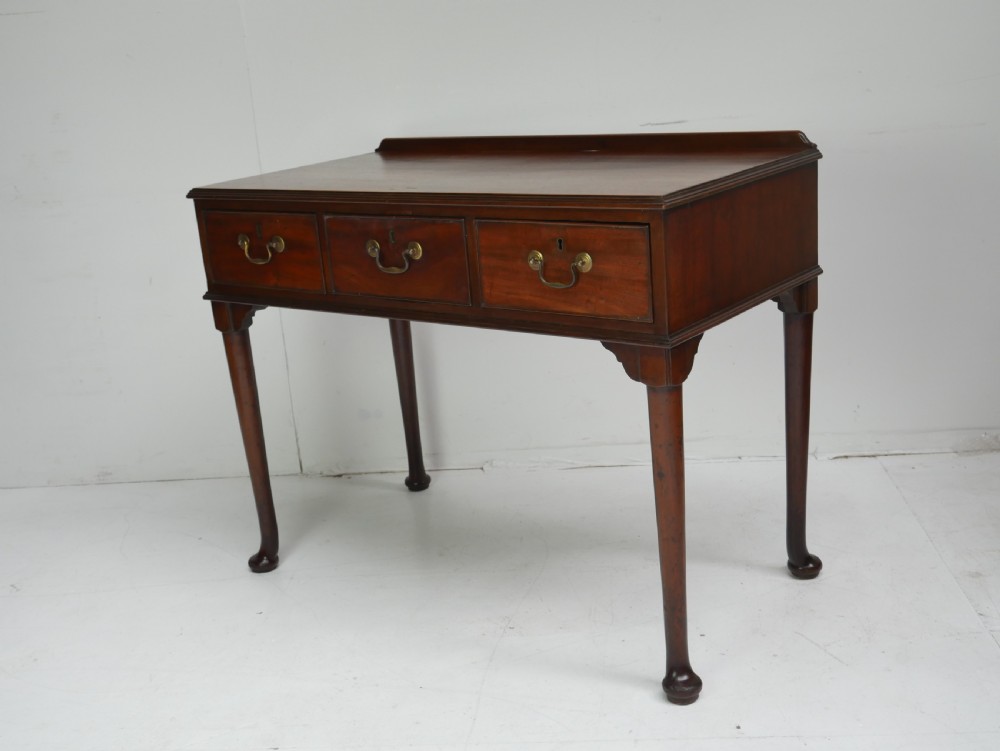 A 19th-century mahogany console table featuring three drawers with brass swan-neck handles and slender cabriole legs ending in pad feet. View VI