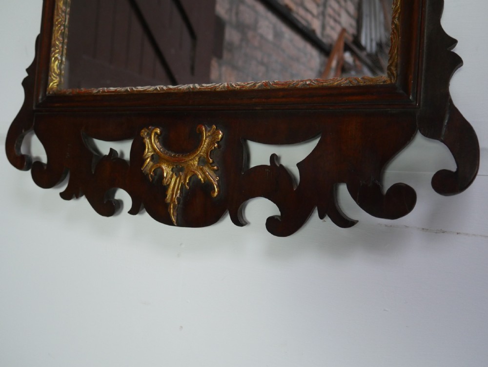 A rectangular Georgian mahogany wall mirror featuring a scroll-cut fretwork frame ornamented with giltwood leaves and cresting. View III