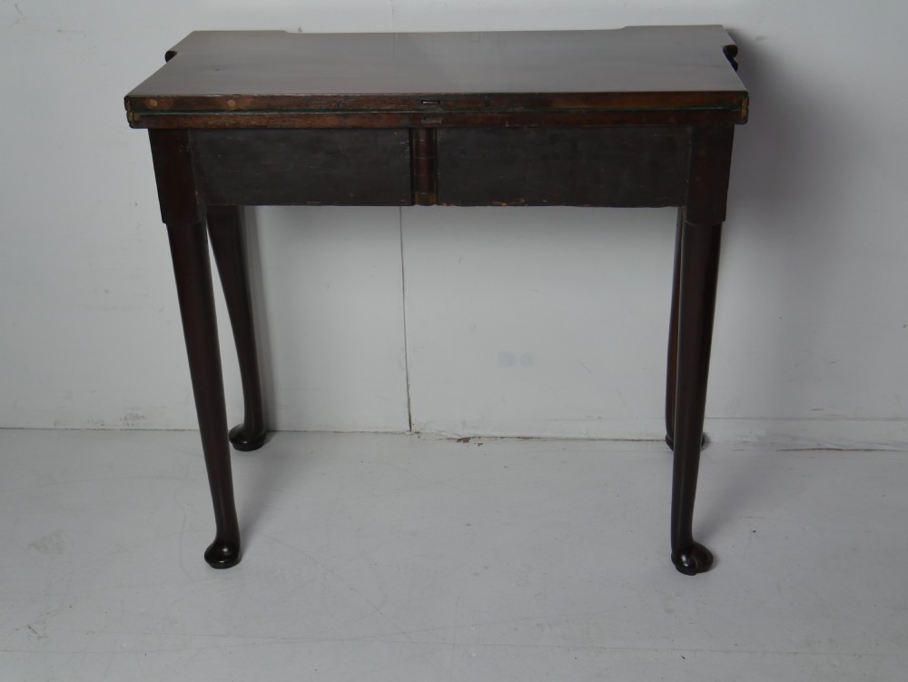 A Georgian mahogany fold-over games table featuring carved cabriole front legs with pad feet and a rectangular top with turret corners. View XV