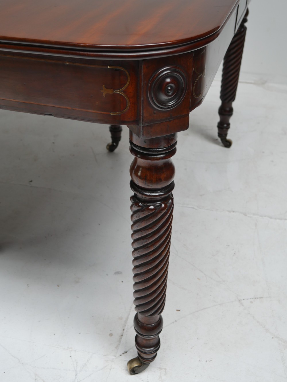 A large antique mahogany extending dining table featuring spiral-turned legs and fitted brass castors. View III