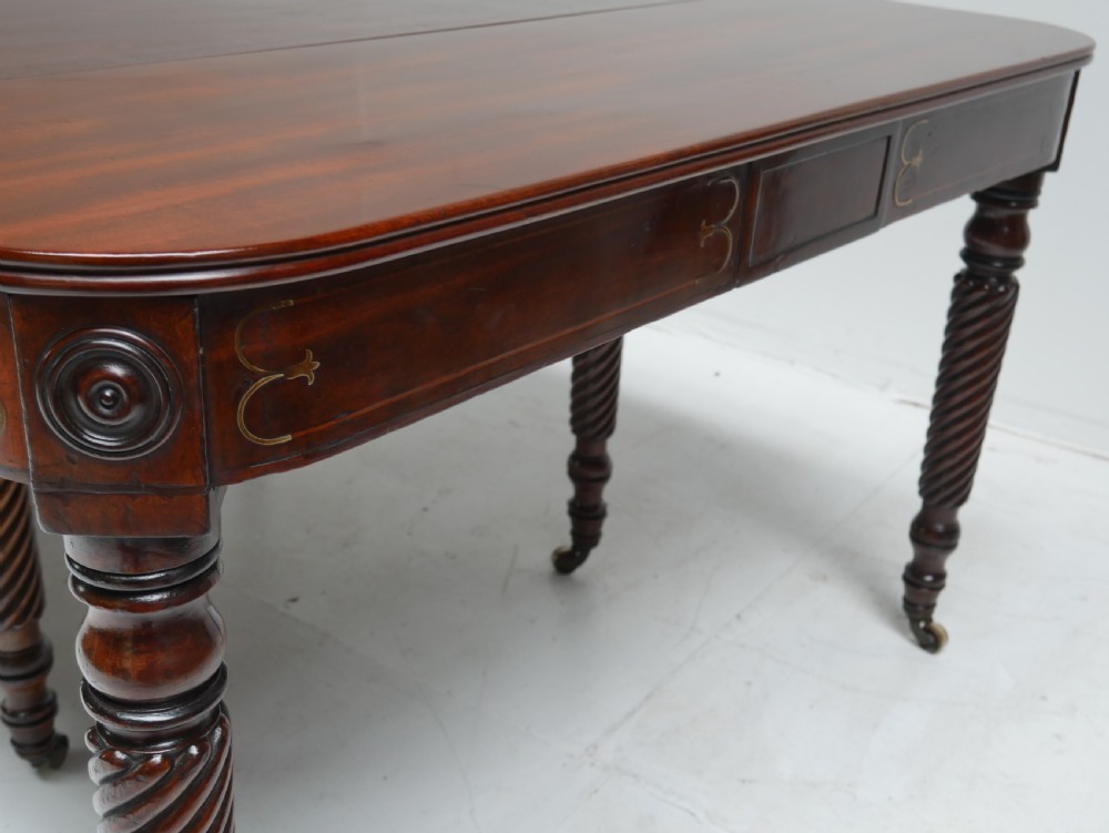 A large antique mahogany extending dining table featuring spiral-turned legs and fitted brass castors. View V