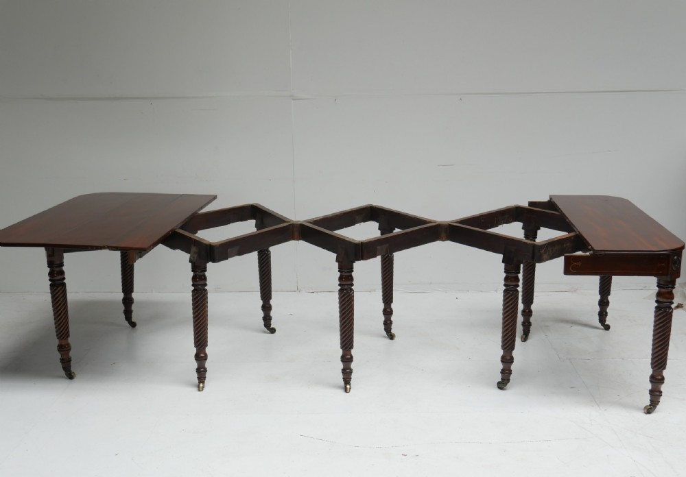 A large antique mahogany extending dining table featuring spiral-turned legs and fitted brass castors. View XI
