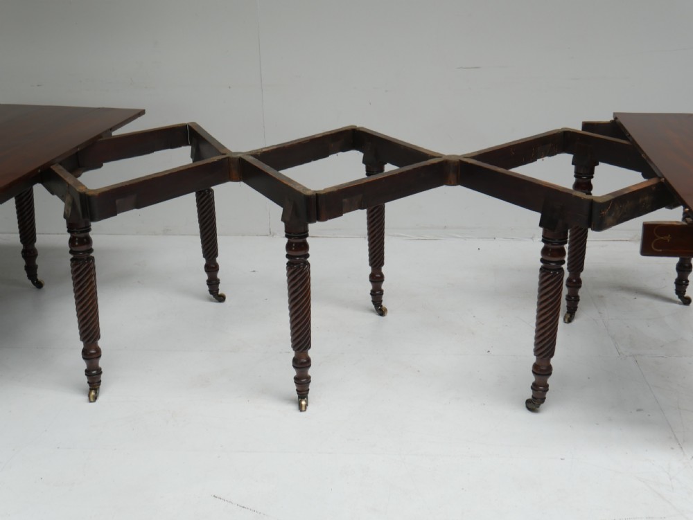 A large antique mahogany extending dining table featuring spiral-turned legs and fitted brass castors. View XII