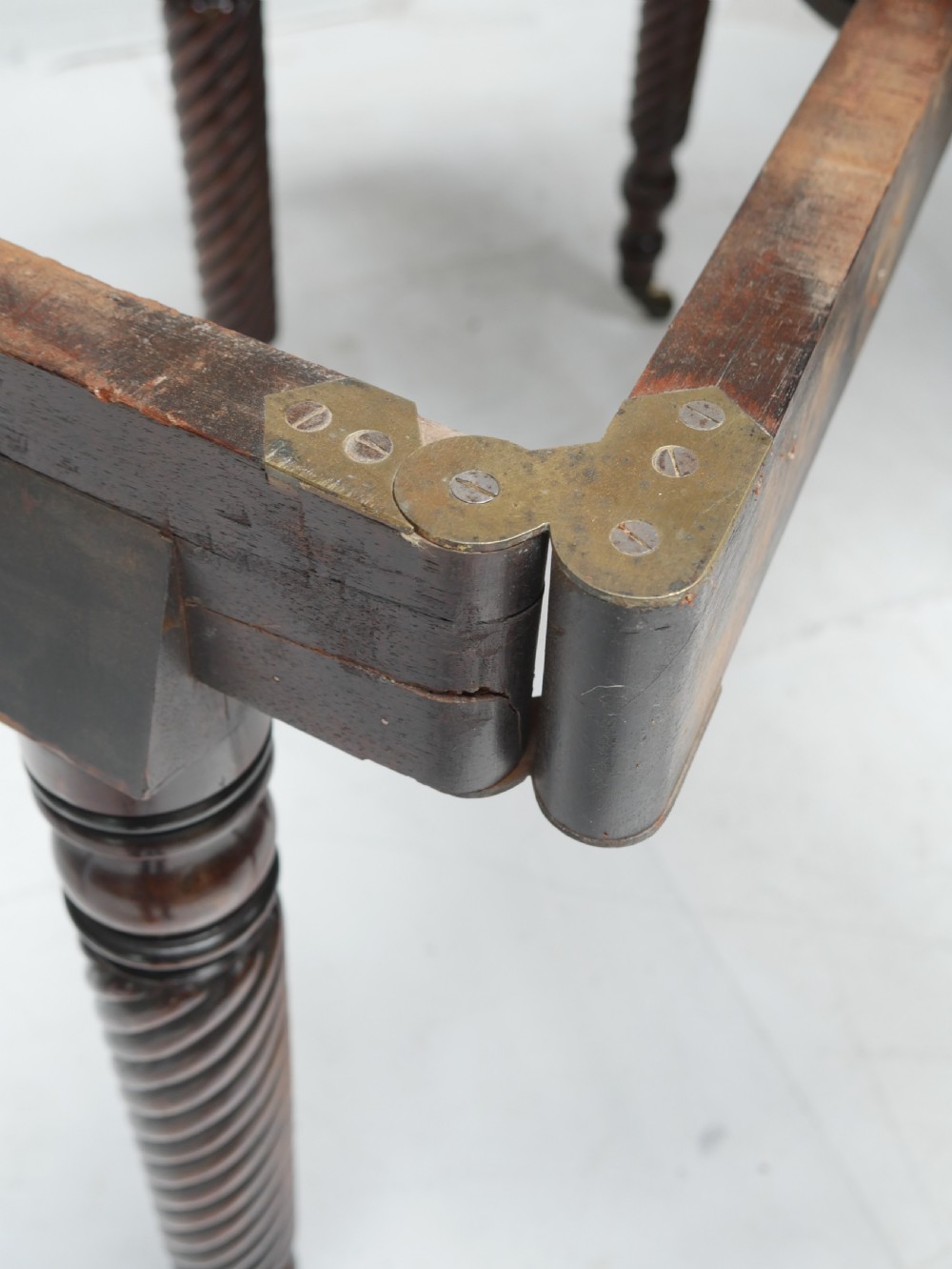 A large antique mahogany extending dining table featuring spiral-turned legs and fitted brass castors. View XIV