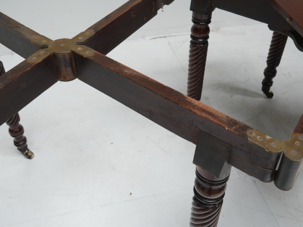 A large antique mahogany extending dining table featuring spiral-turned legs and fitted brass castors. View XV