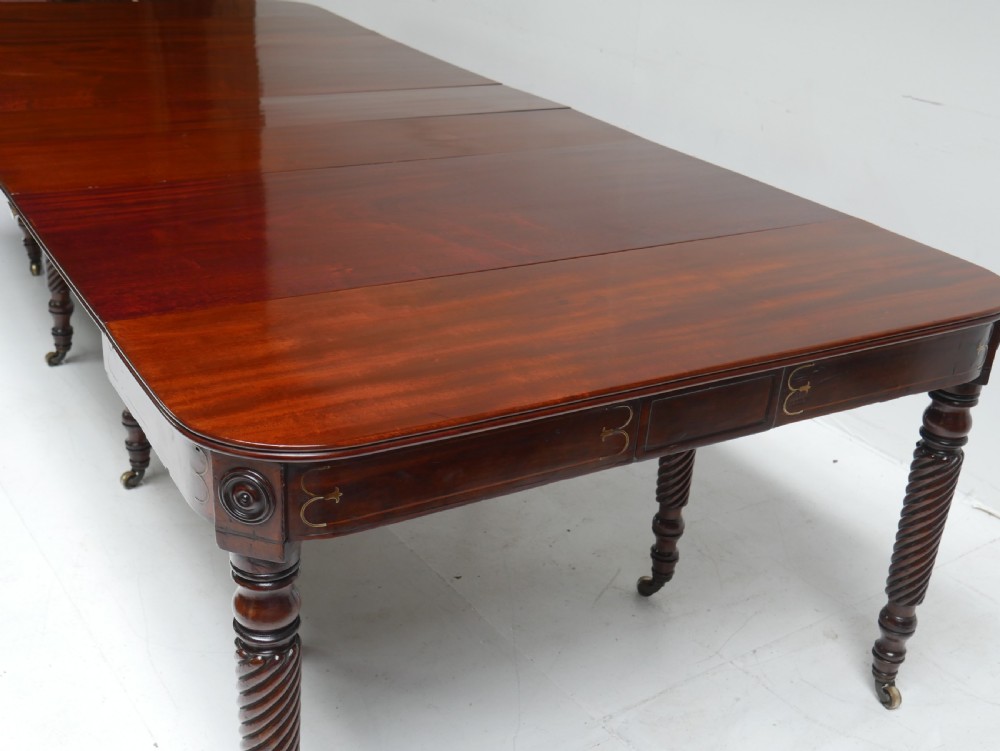 A large antique mahogany extending dining table featuring spiral-turned legs and fitted brass castors. View XIX