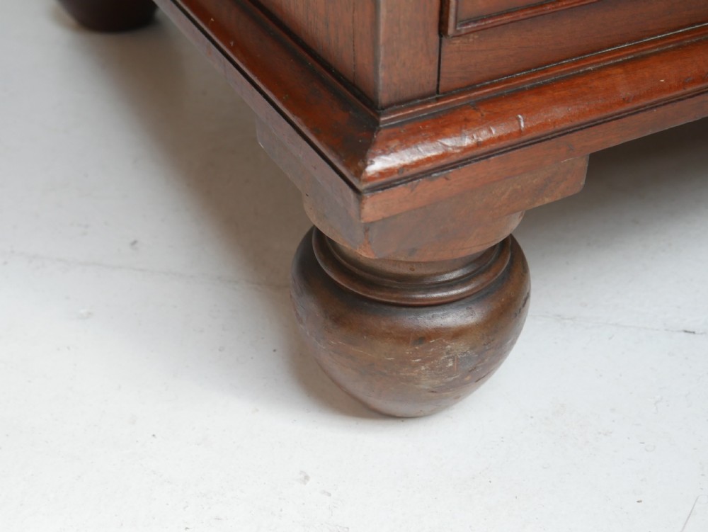 A classic Regency mahogany chest featuring four horizontal drawers with flame mahogany grain, turned wooden knobs, brass keyhole escutcheons, and turned feet. View II