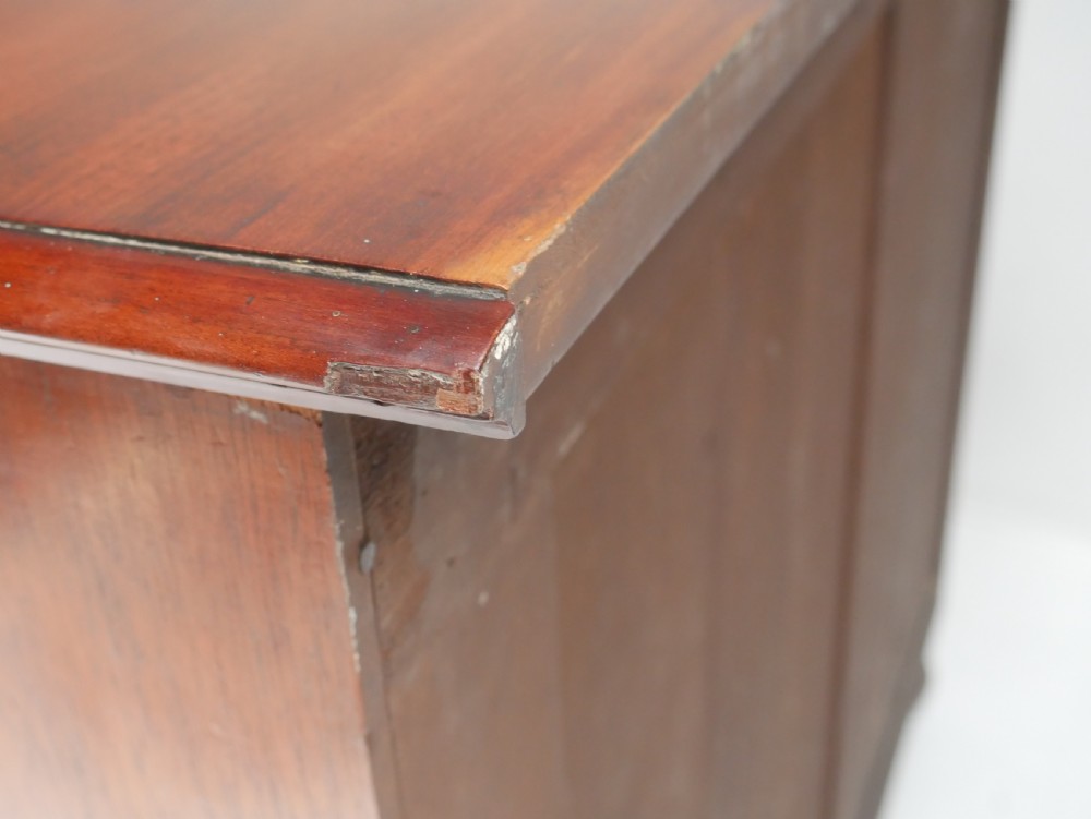 A classic Regency mahogany chest featuring four horizontal drawers with flame mahogany grain, turned wooden knobs, brass keyhole escutcheons, and turned feet. View IX