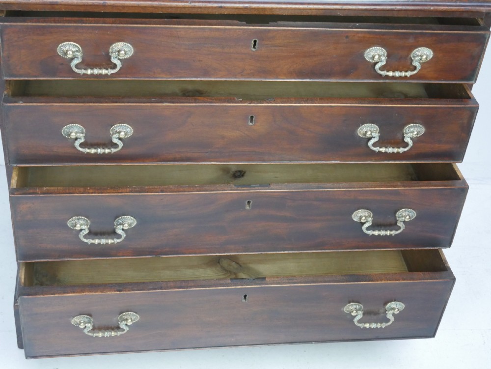 A Georgian mahogany chest of drawers featuring four graduated drawers with brass swan-neck handles and bracket feet. View III