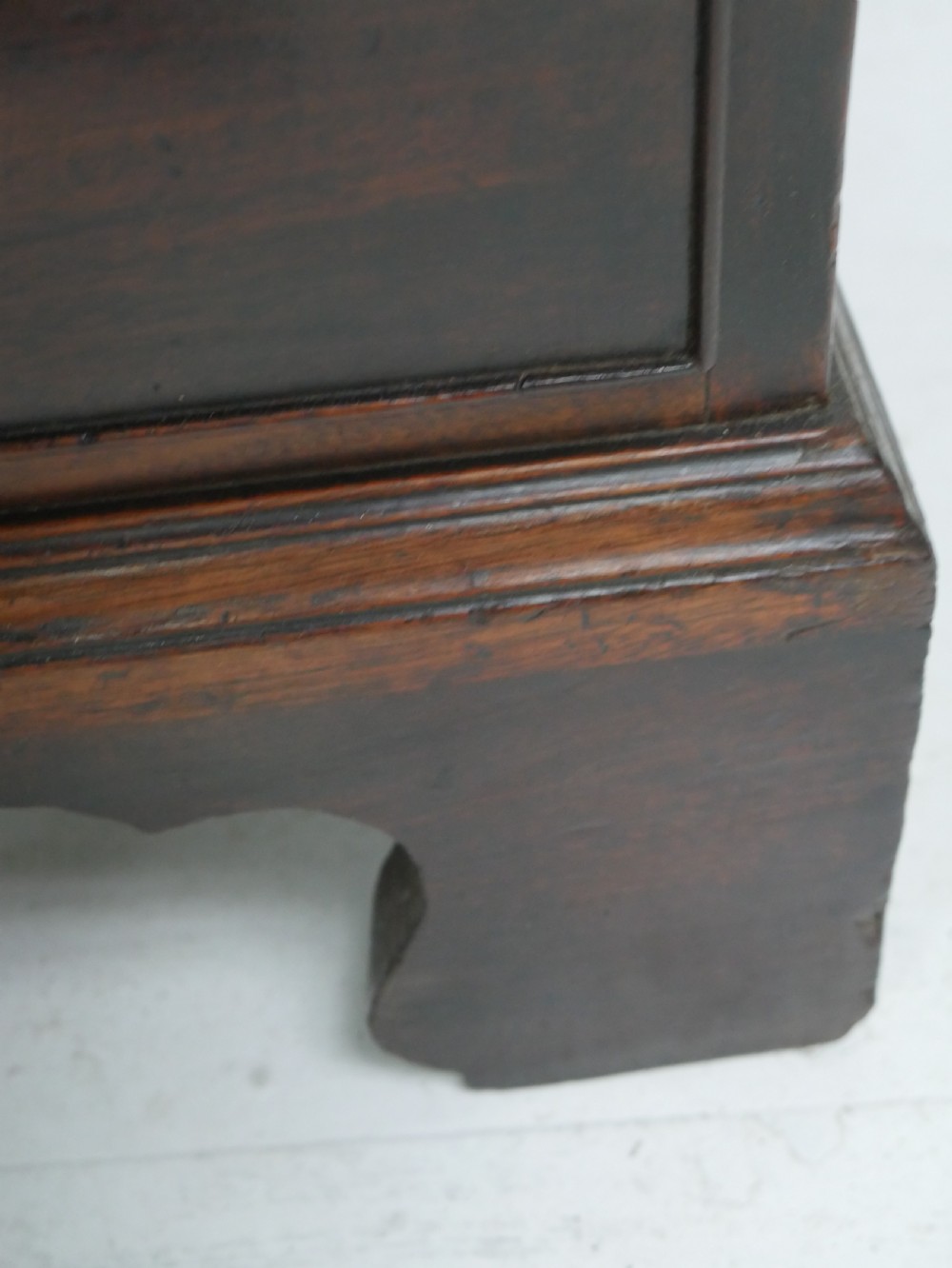 A Georgian mahogany chest of drawers featuring four graduated drawers with brass swan-neck handles and bracket feet. View V