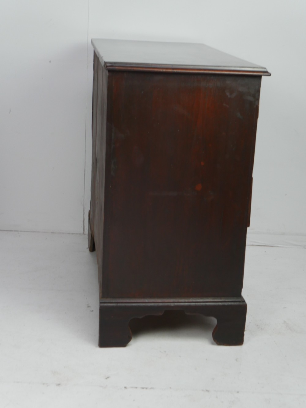A Georgian mahogany chest of drawers featuring four graduated drawers with brass swan-neck handles and bracket feet. View VIII