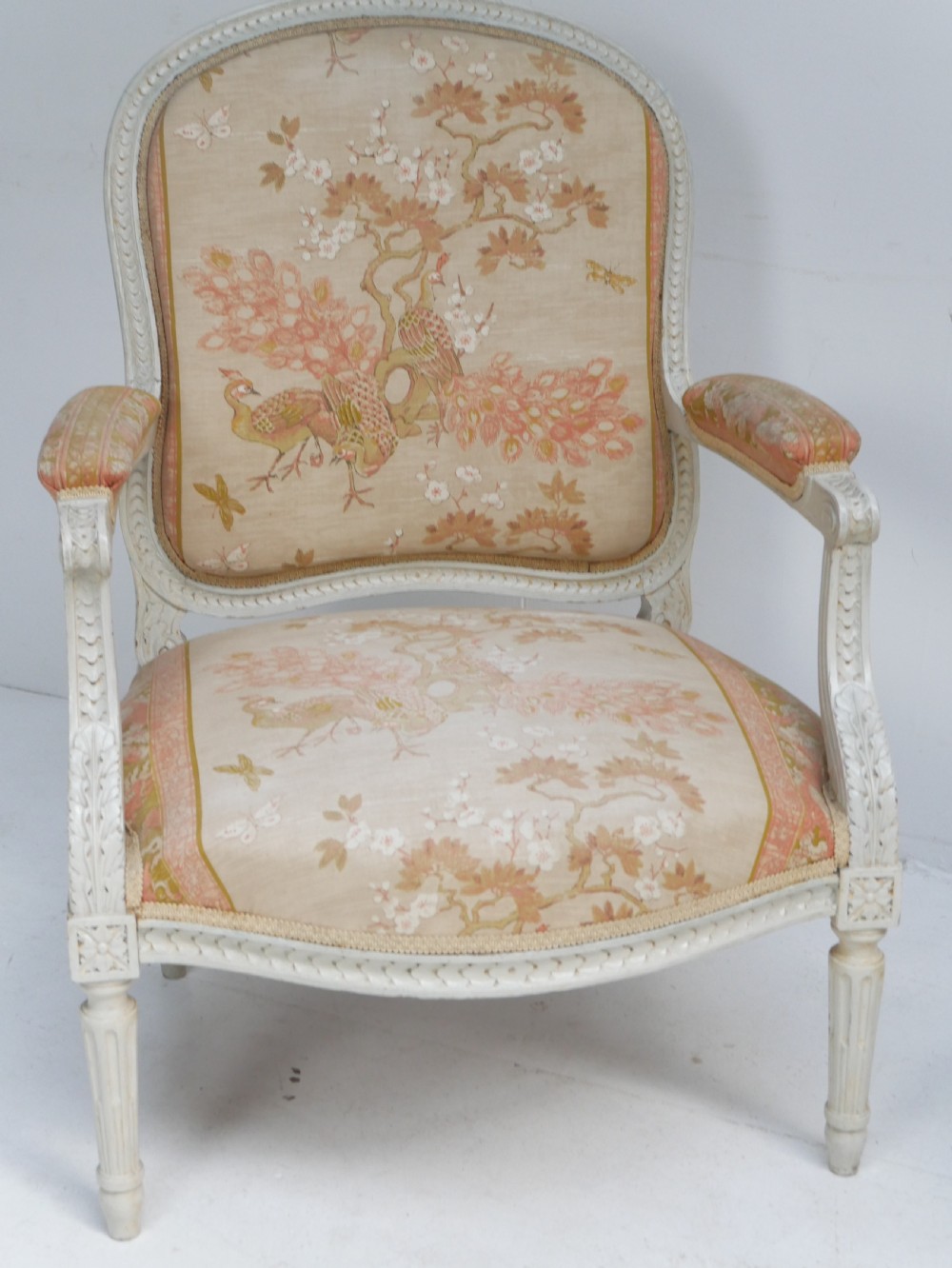A pair of French Louis XVI style fauteuil armchairs featuring off-white painted frames, fluted legs, and patterned floral upholstery. View III