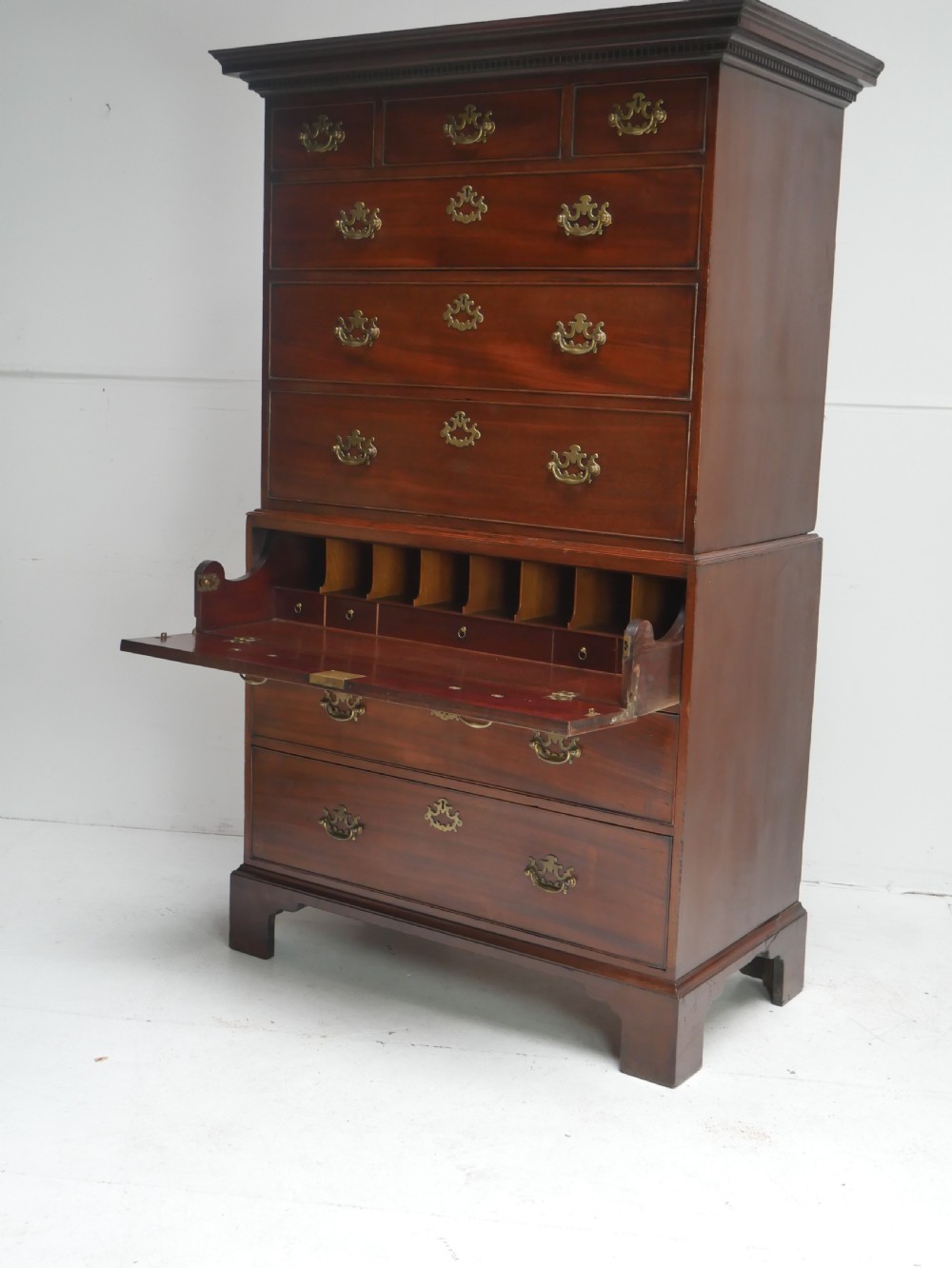 An eighteenth-century Georgian dark mahogany secretaire tallboy featuring two stacked chest sections, brass handles, and bracket feet. View II
