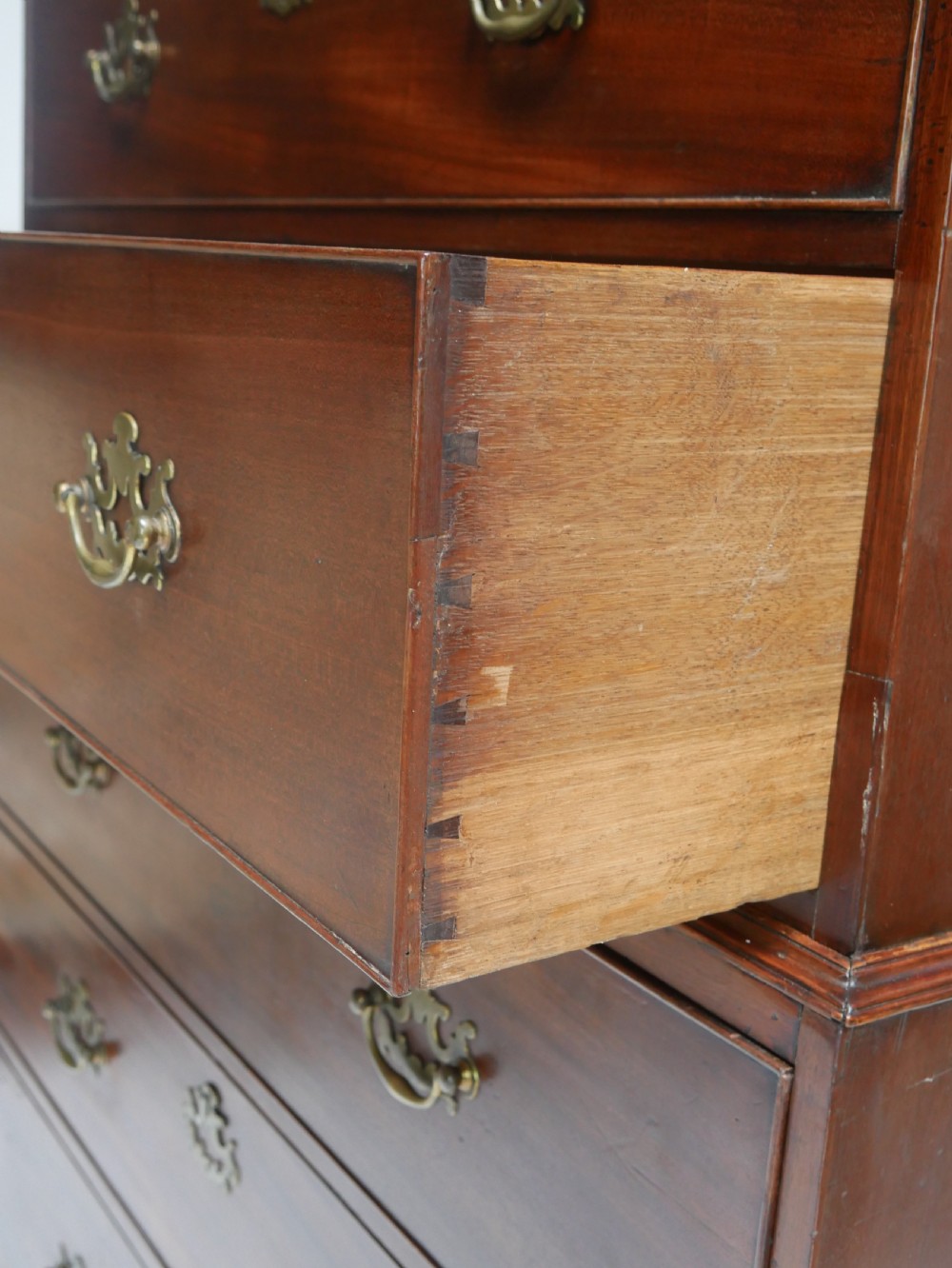 An eighteenth-century Georgian dark mahogany secretaire tallboy featuring two stacked chest sections, brass handles, and bracket feet. View X