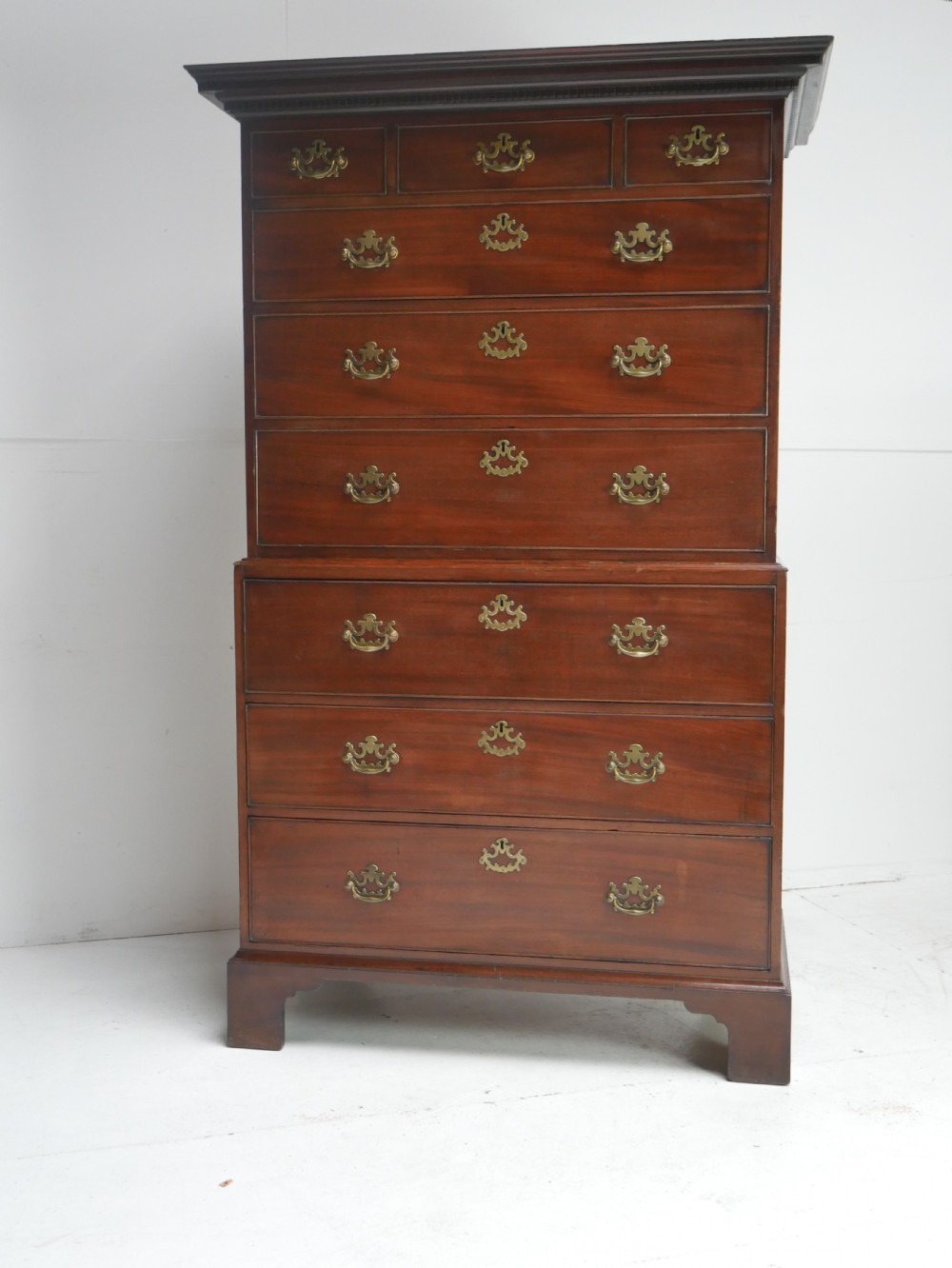 An eighteenth-century Georgian dark mahogany secretaire tallboy featuring two stacked chest sections, brass handles, and bracket feet. View XIX