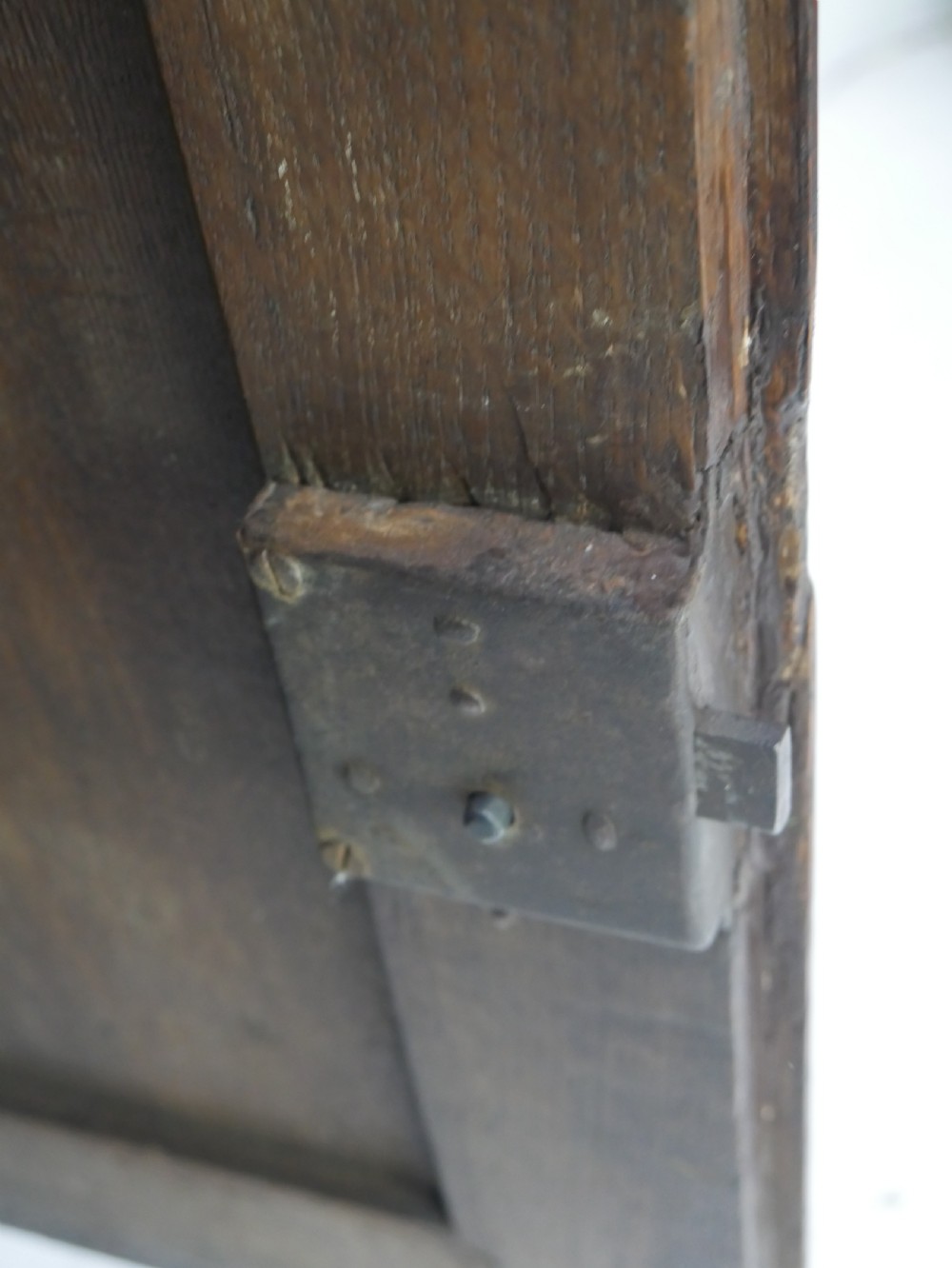 An 18th-century dark oak hanging cupboard featuring a carved shell cresting, a single fielded panel door with brass key escutcheon, and two small base drawers. View XI